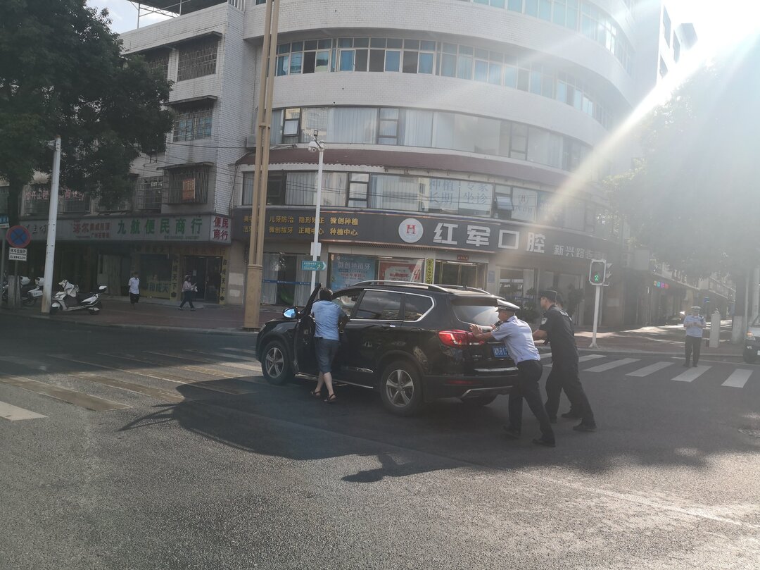 车辆烈日下抛锚，祁阳交警推车解困境